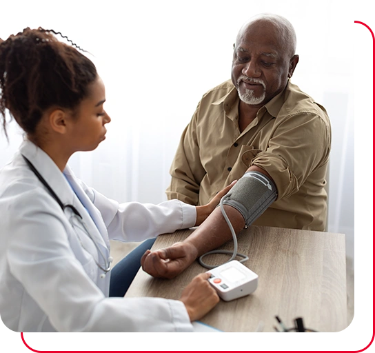 Young Female Medical Worker Measuring Arterial Blood Pressure Of Senior Black Man Using Cuff
